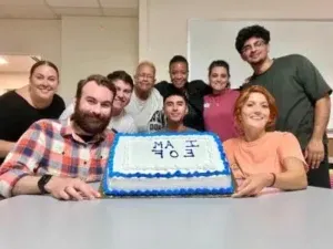 Group of students holding a cake that says "I am EOF"