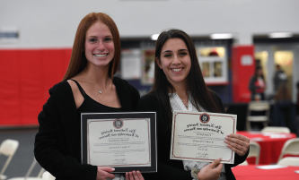 two students holding their diploma